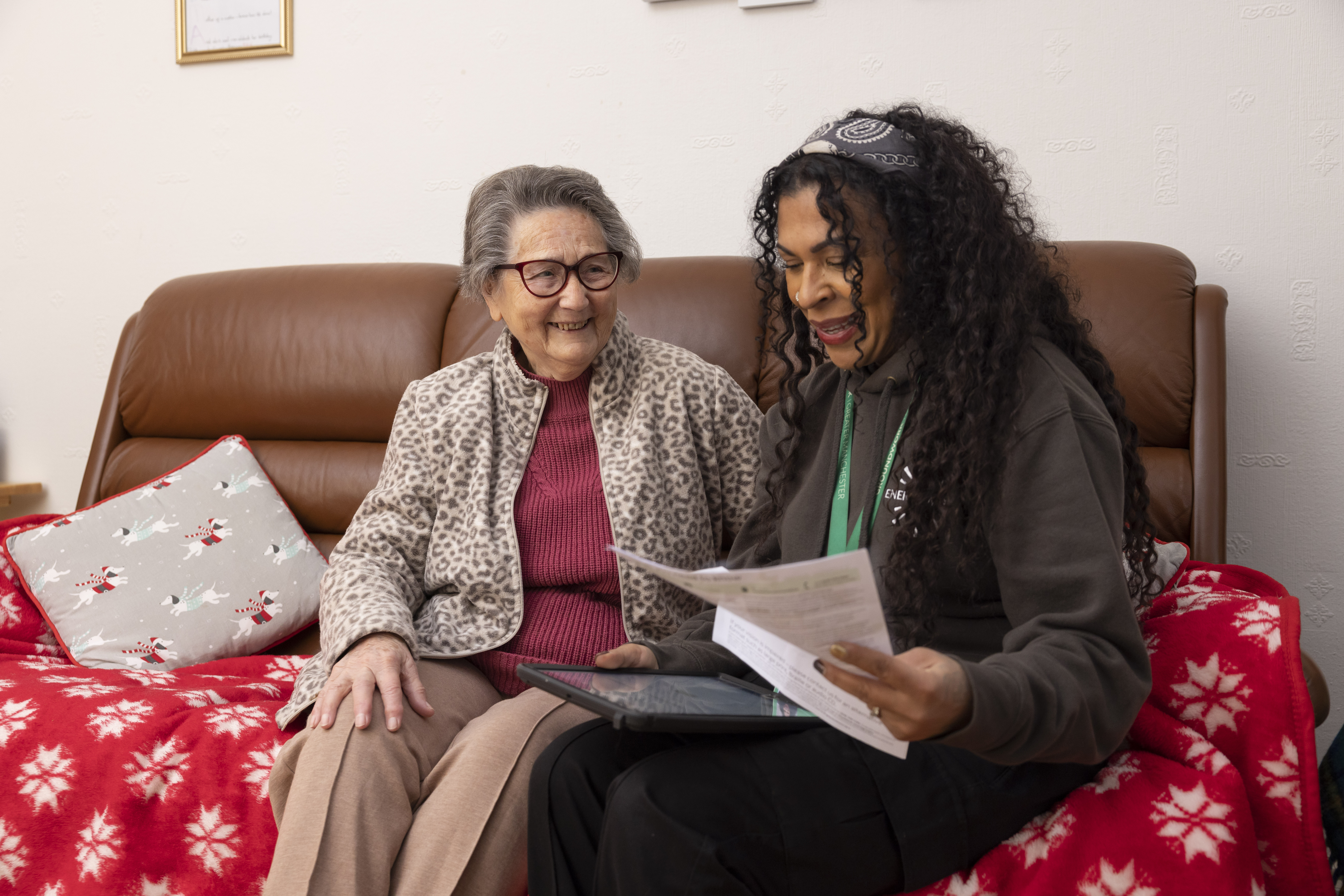 Photo of a woman sitting on a couch with an older women engaging in a conversation about energy.