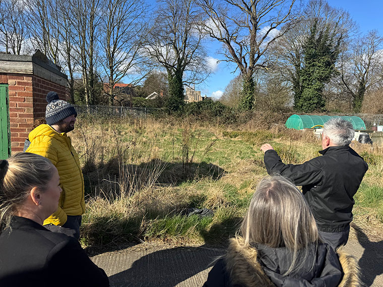 Group of people looking at grassy field.