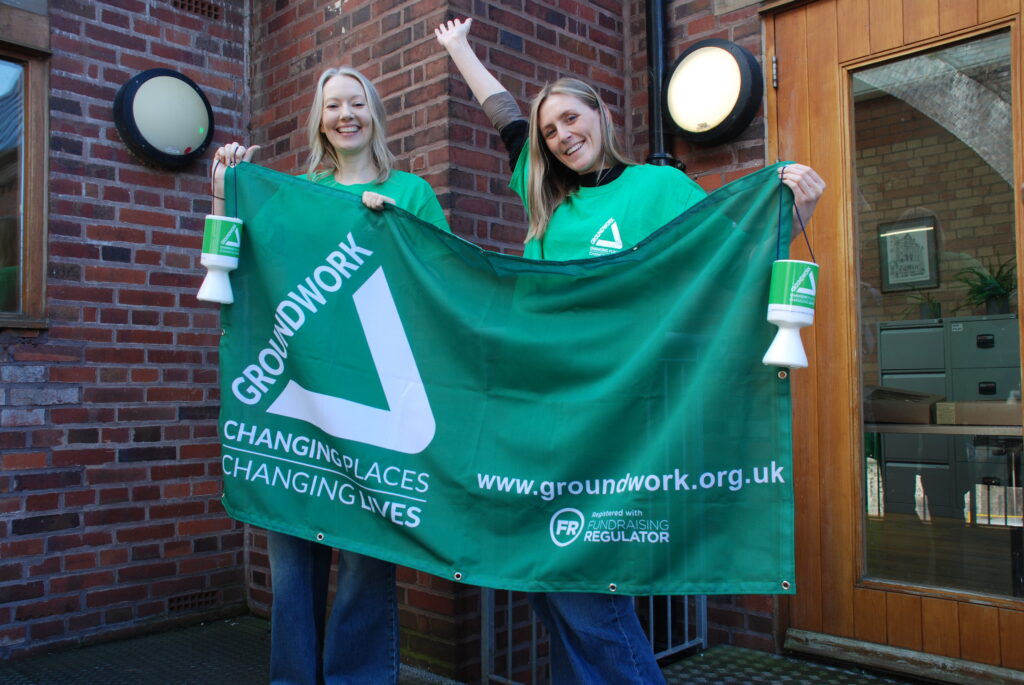 Two women holding Groundwork banner and donation buckets
