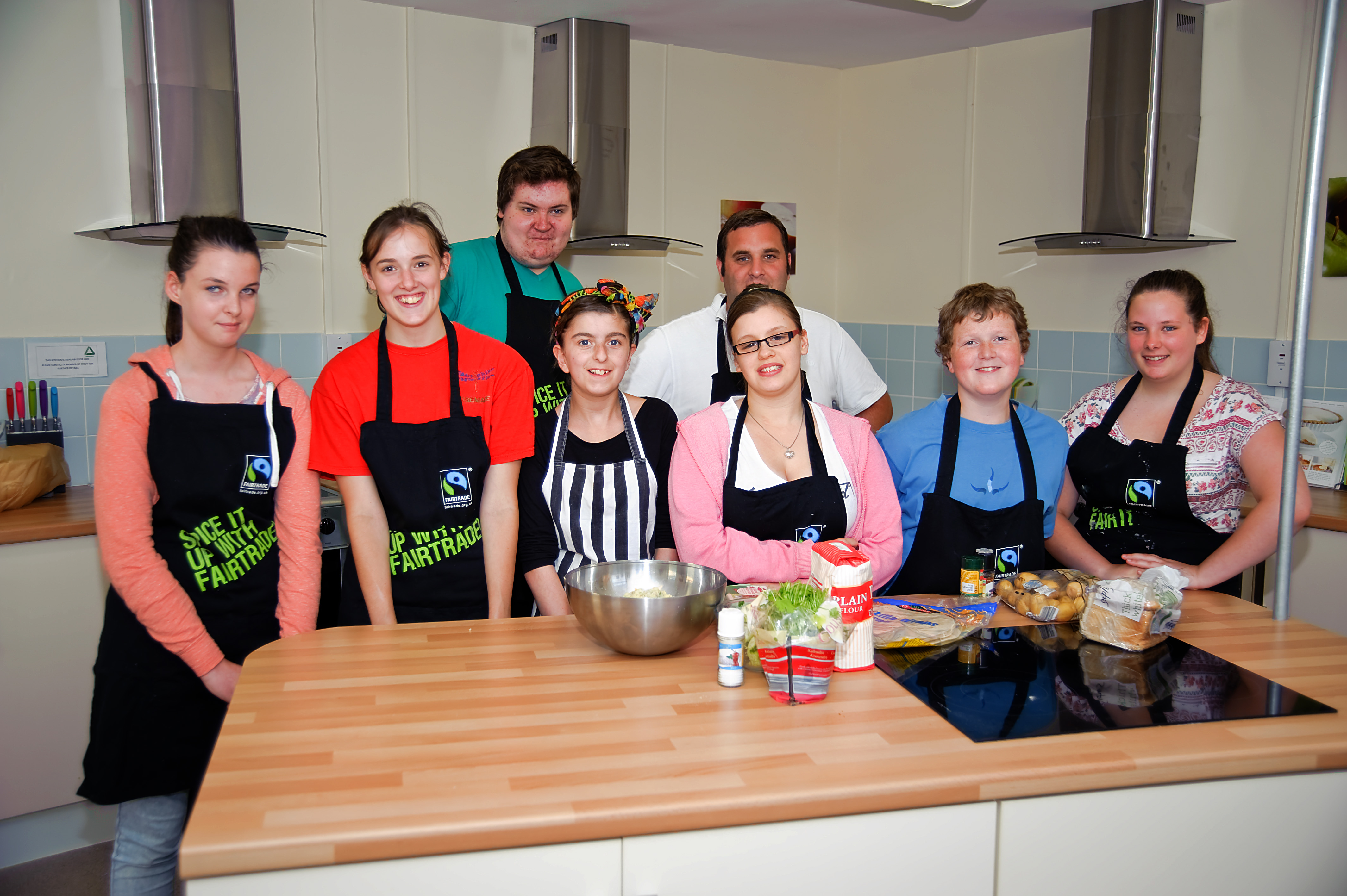 Group of five volunteers in aprons in the demo kitchen at Groundwork Wales' head office.