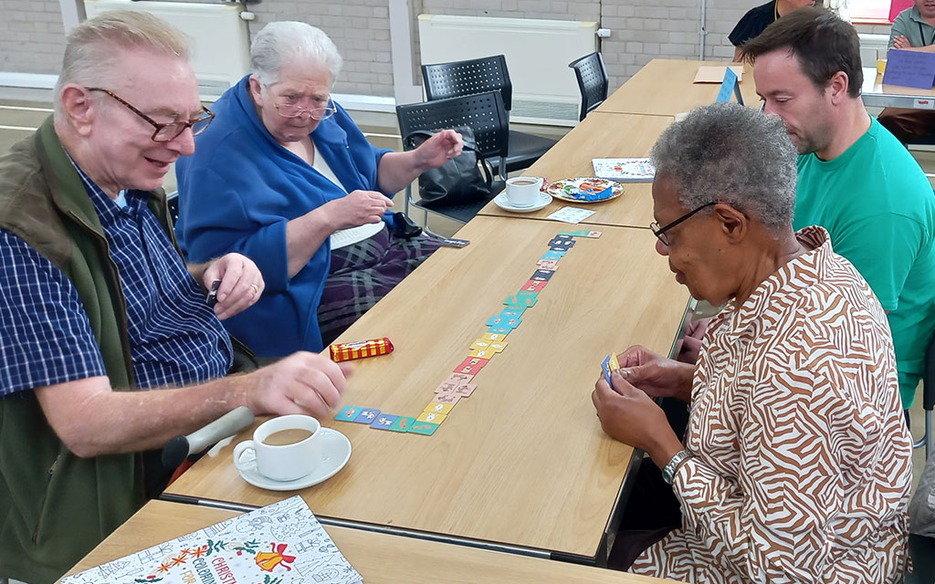 Group of people of different ages playing table top game.