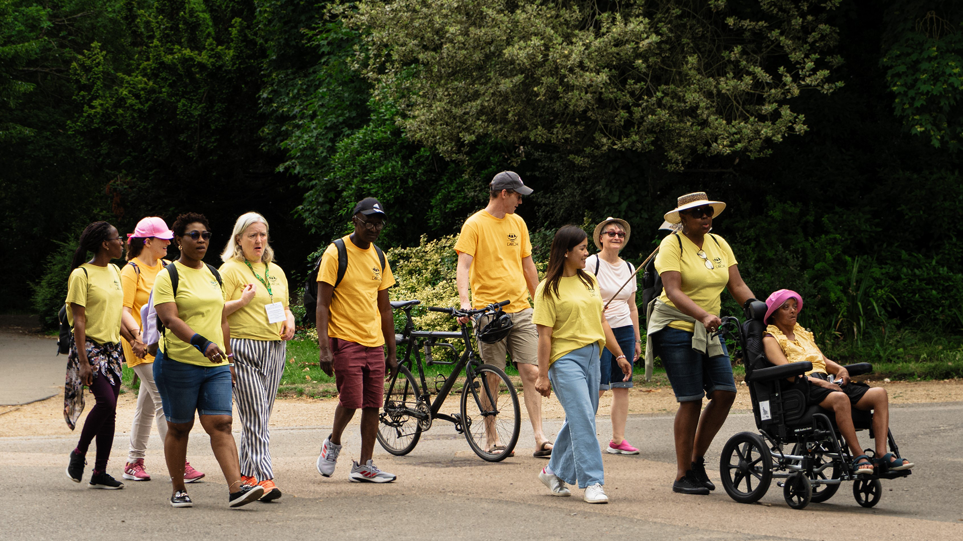 Diverse group of people walking with bicycles and in wheelchairs