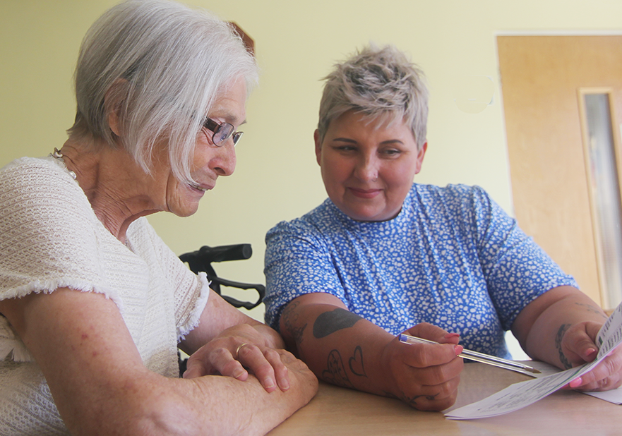 Two women at table looking at paper