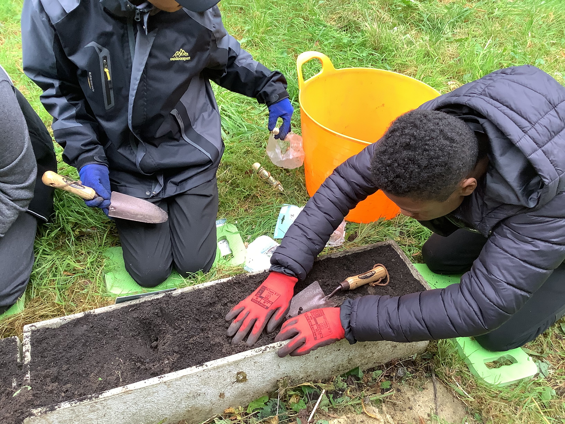 Children planting seeds outside