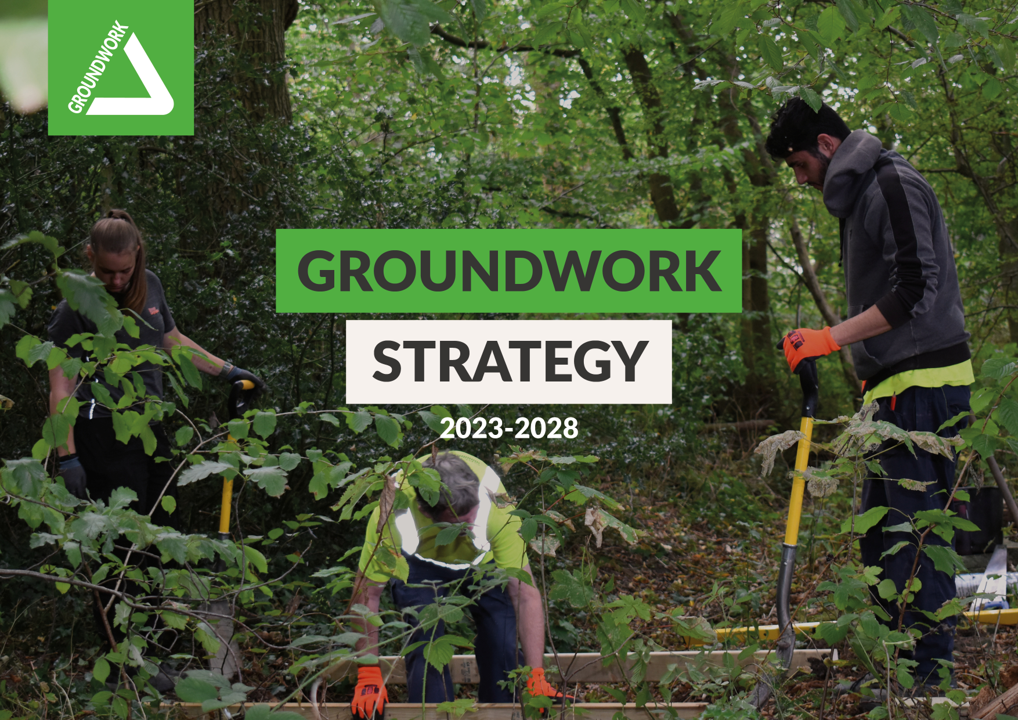 Image displaying volunteers working on a project in a wooded area. The word 'groundwork strategy 2023 - 2028 are displayed across the front of the image with the groundwork logo top left.